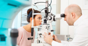 An eye doctor examines a patient through a slit lamp